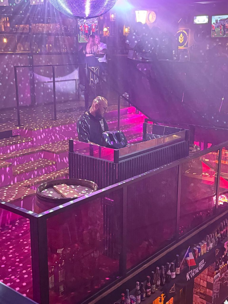 Simba Léone en cabine, au-dessus d’un bar éclairé en rose