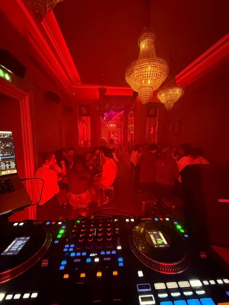 Club éclairé en rouge, public et lustres en cristal