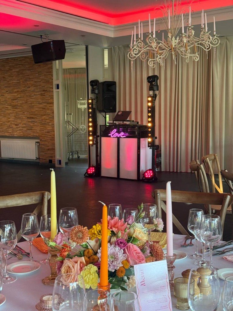 Table de mariage fleurie, stand DJ et néon love au fond de la salle